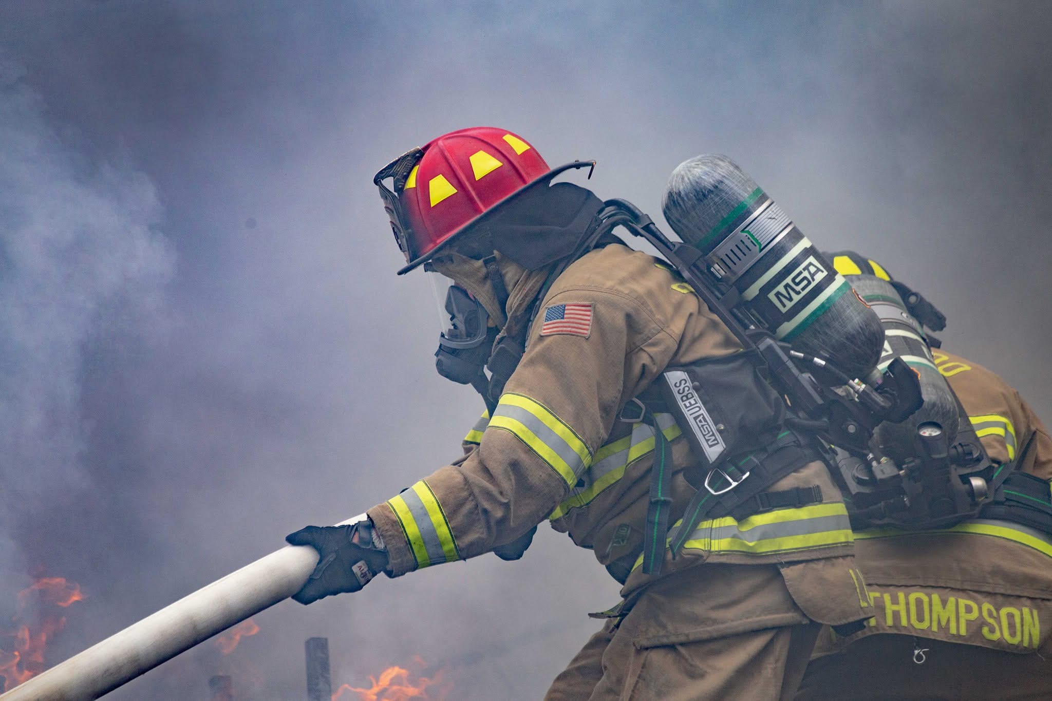 Baraboo Area Fire and EMS District firefighters advancing a hose line through smoke and fire.